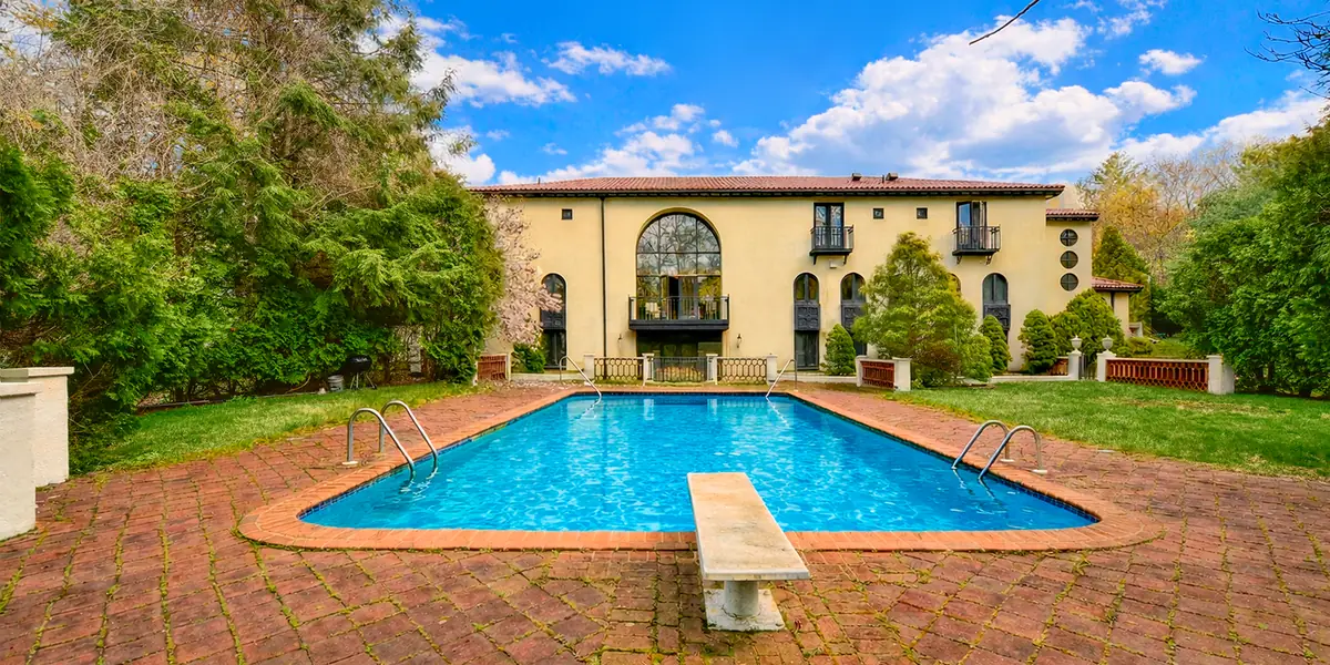 A pool and courtyard under a blue sky